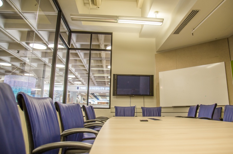 Photo of conference table, chairs, projection screen, and whiteboard in the Bryan Center Griffith Board Room