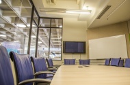 Photo of Bryan Center Griffith Board Room showing conference table chairs, projection screen, and whiteboard